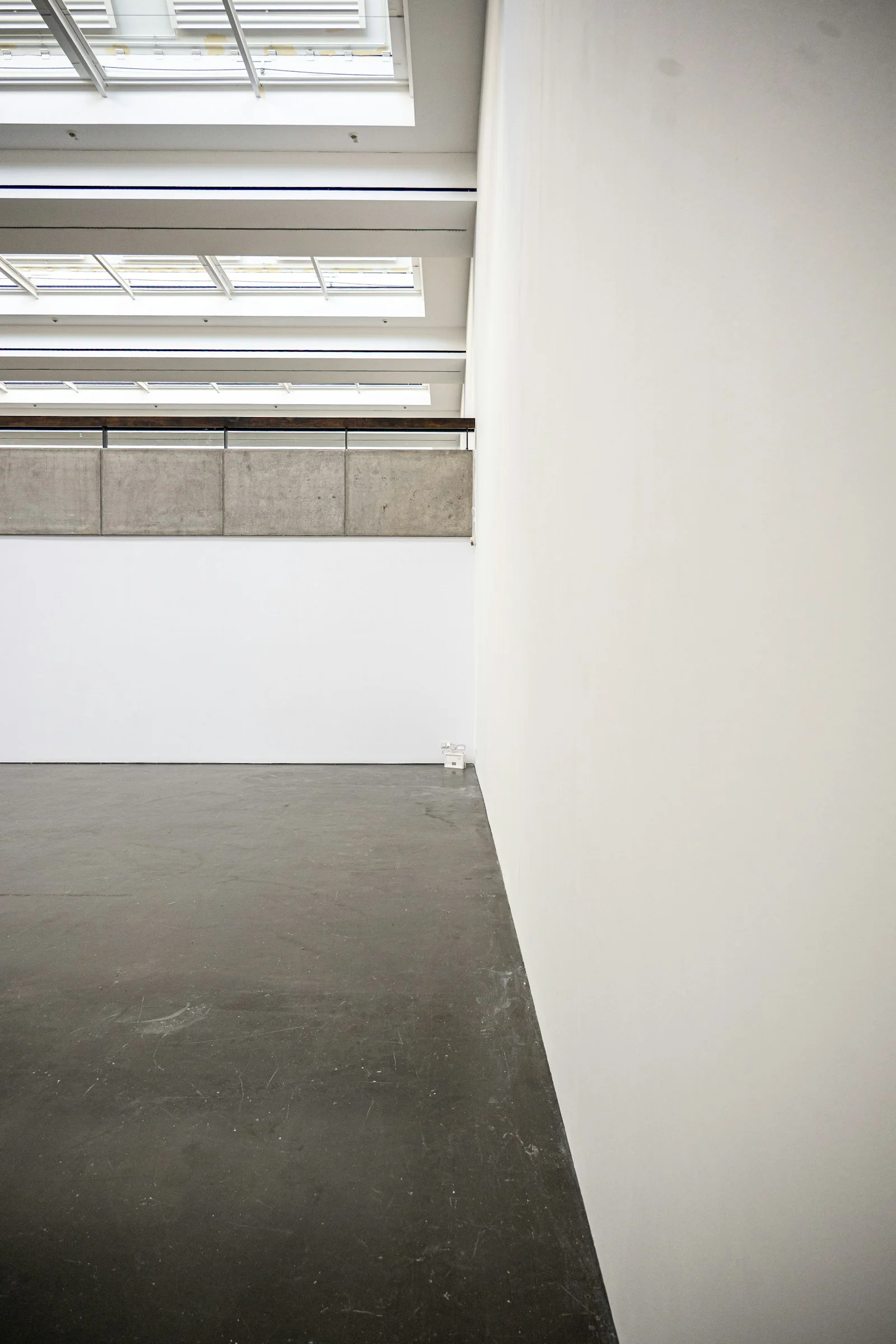 Interior de arquitectura contemporánea con hormigón, planos blancos y luz natural.